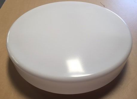 White round plastic container with a domed lid on a brown surface