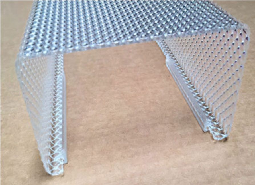 Small silver perforated metal table or stool with two front legs on a cardboard surface