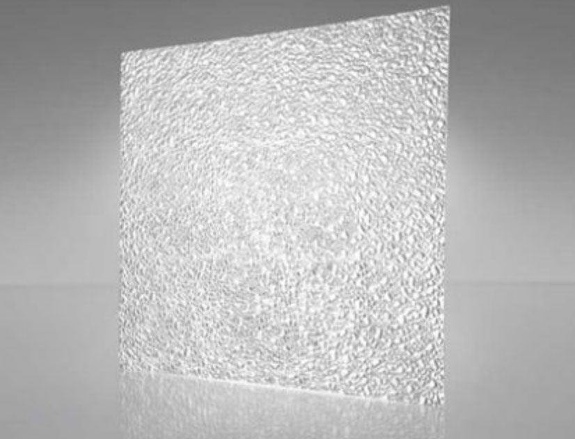 Textured frosted glass panel standing on a gray surface, lit from the side
