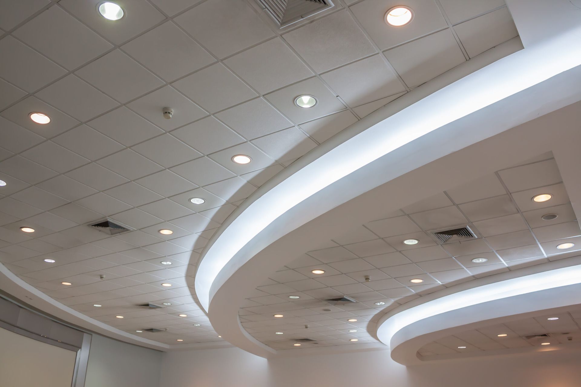 Curved white ceiling with recessed lights in a modern interior space