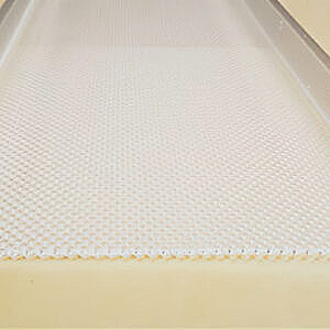 White textured mat or tray liner on a pale yellow surface