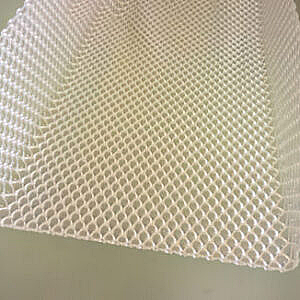 Close-up of a white mesh fabric with a diagonal pattern on a light background