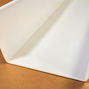 Close-up of a folded white paper on a tan surface