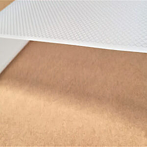 White textured sheet partially covering a tan surface with a diagonal shadow