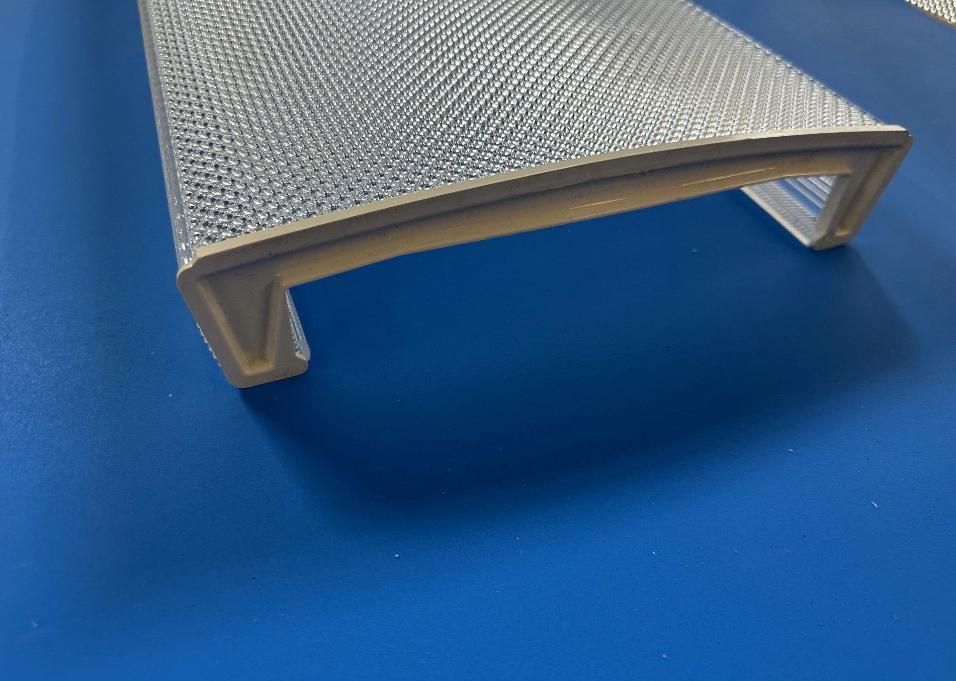 Silver textured step stool on a blue surface