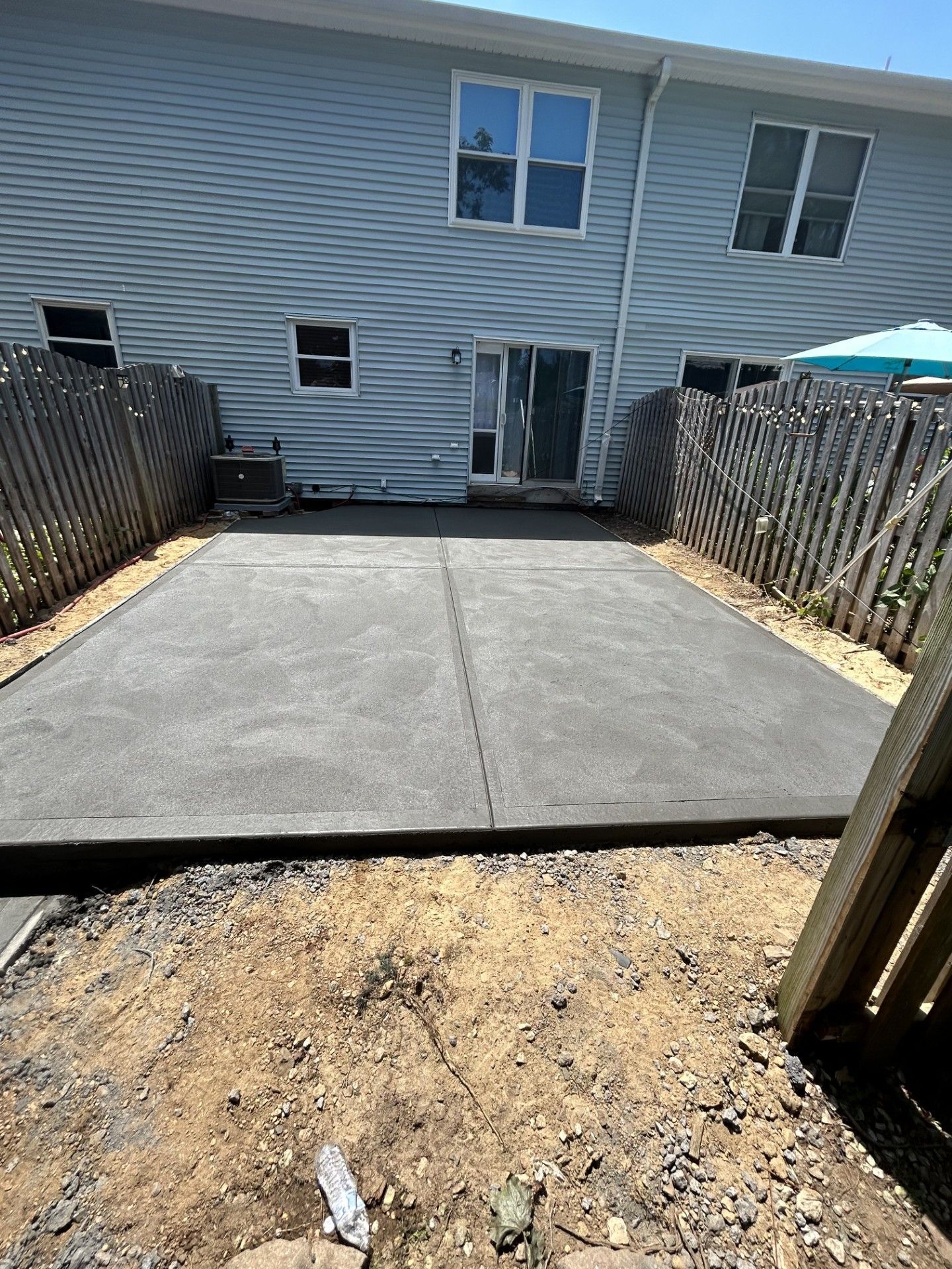 A concrete driveway is being built in front of a house.