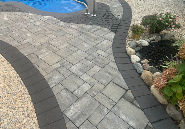 A brick walkway leading to a swimming pool