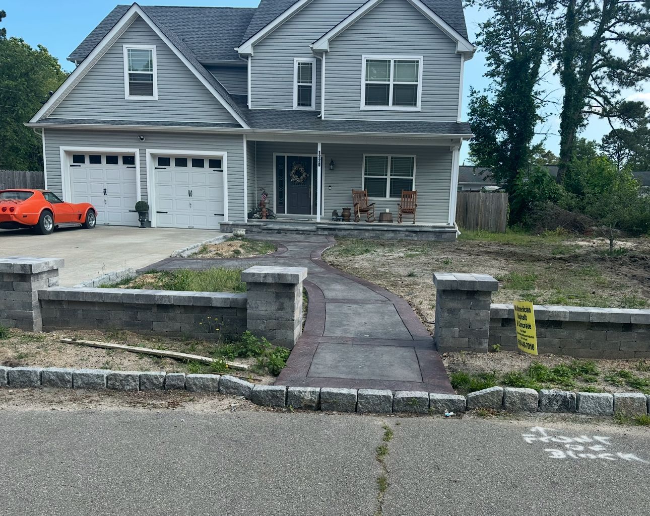 A house with a red car parked in front of it