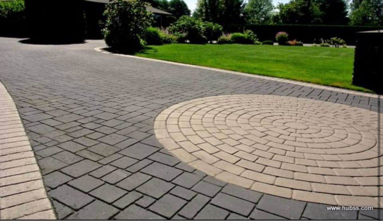 A brick driveway with a circular design in the middle