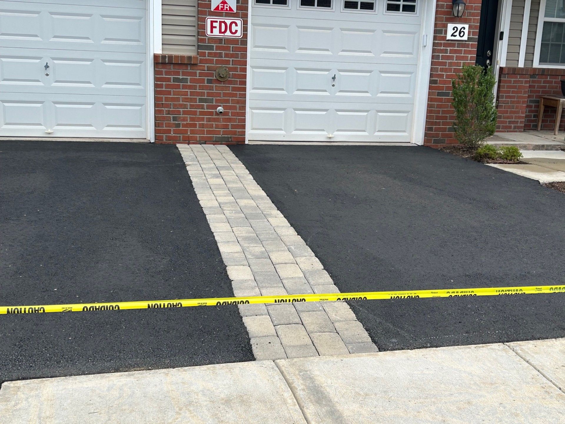 A driveway in front of a brick house