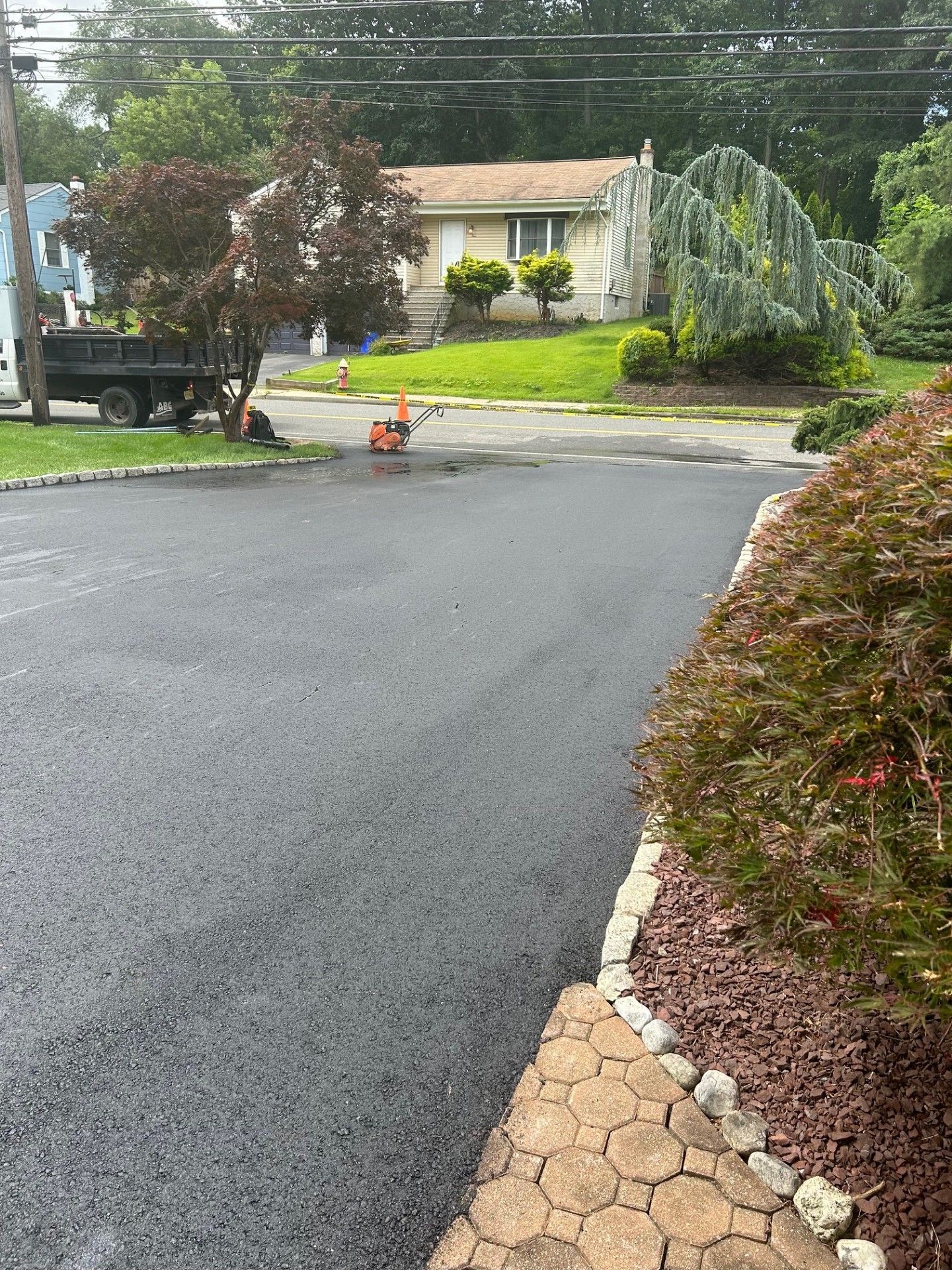 A black truck is parked on the side of the road in front of a house.