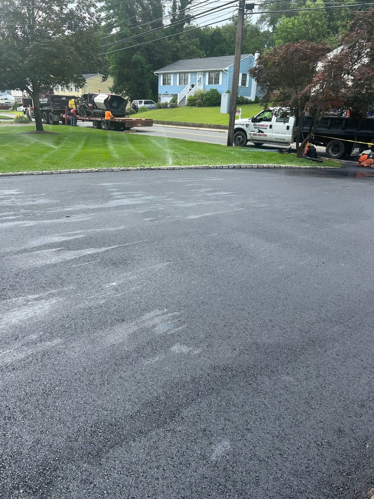A truck is parked in a parking lot next to a house.