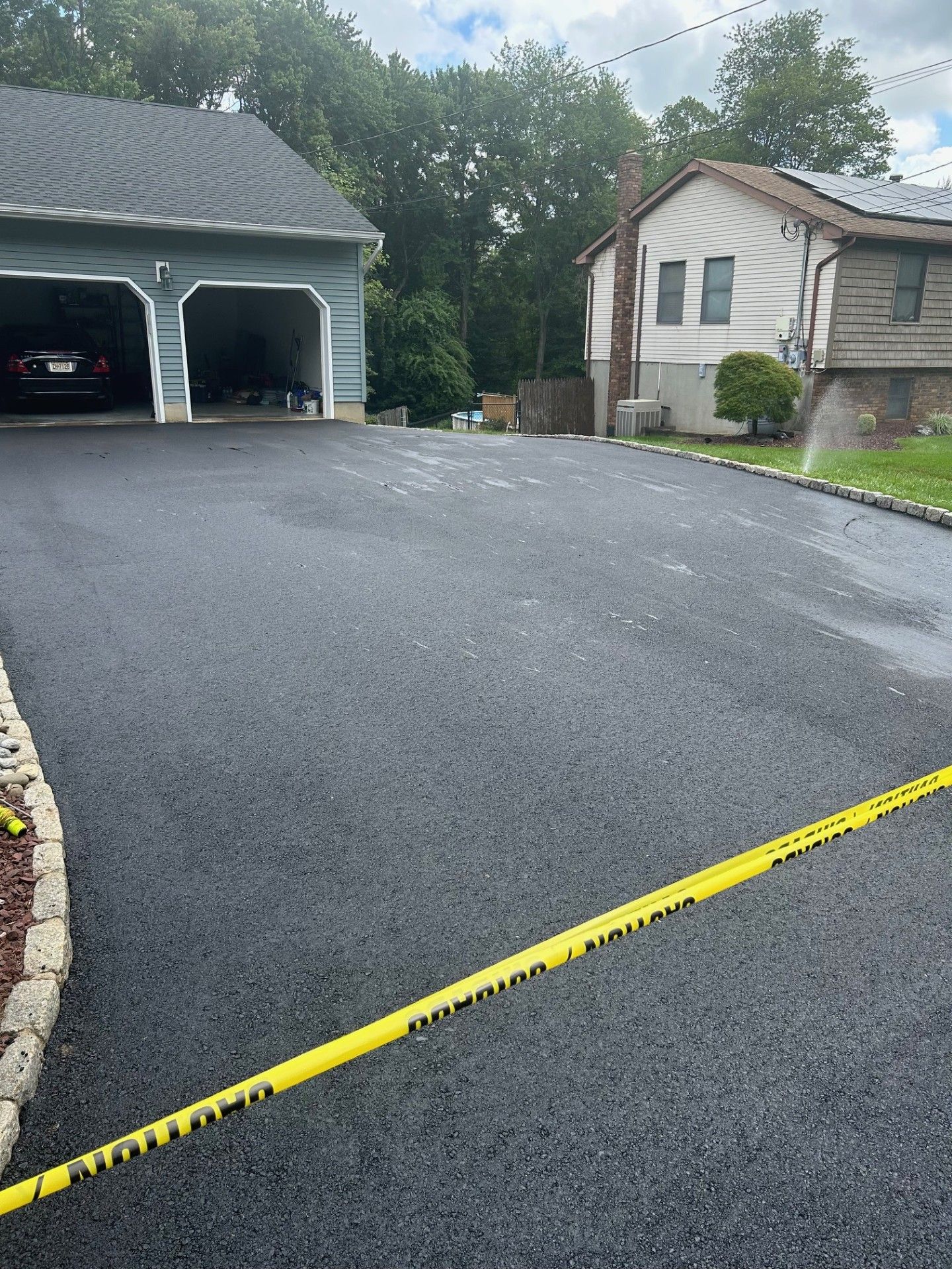 A car is parked in a garage next to a house.