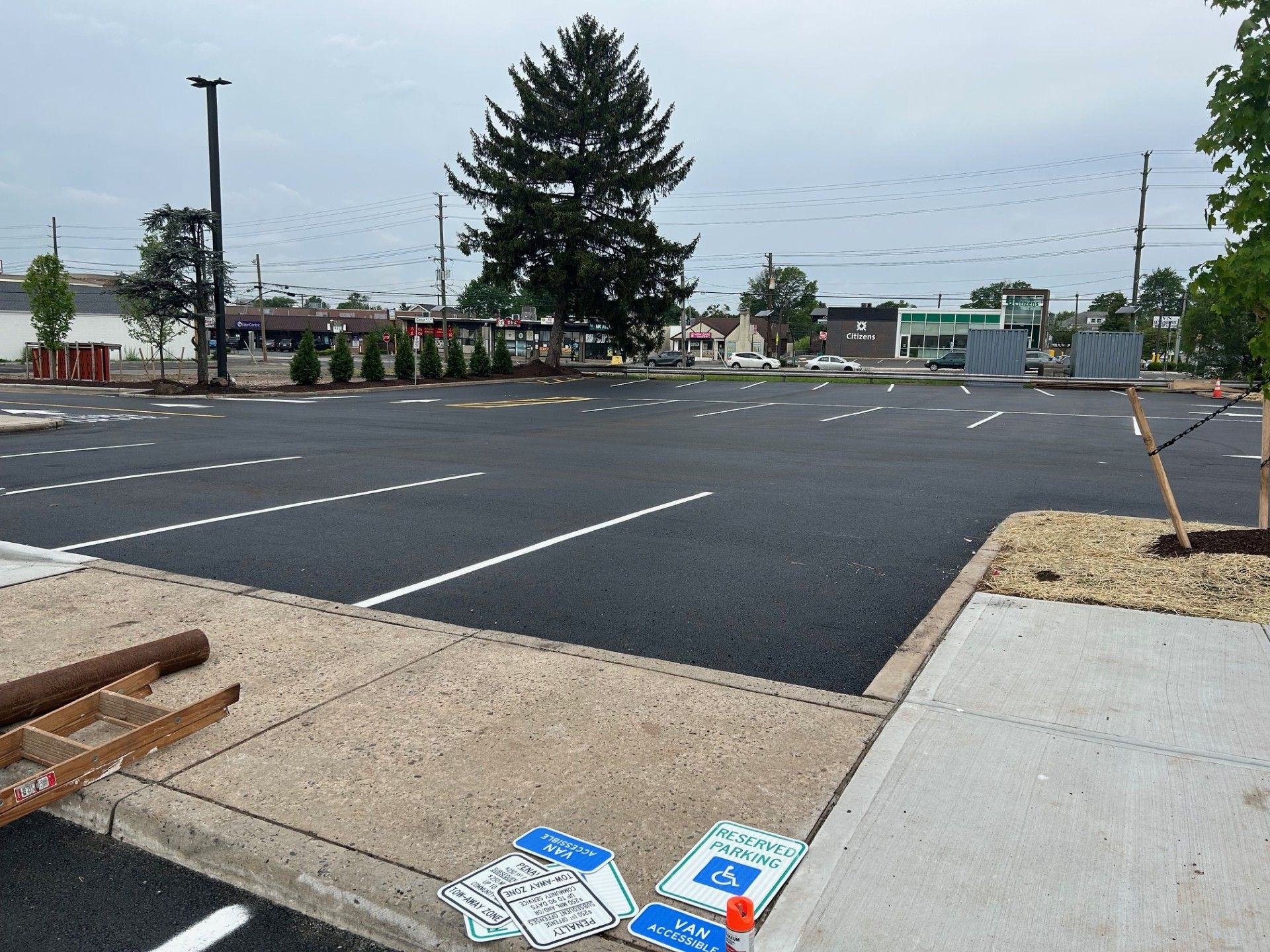 A parking lot with a handicapped sign on the sidewalk.