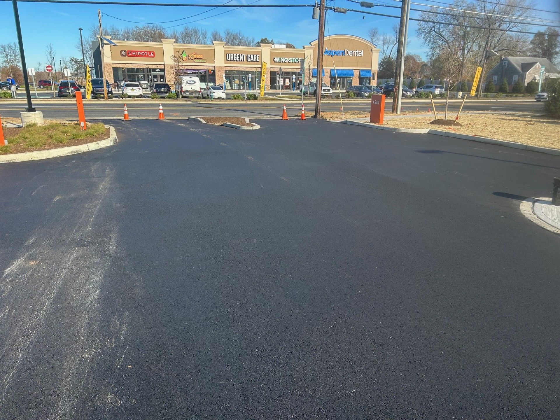 A parking lot with a lot of cones and a store in the background.