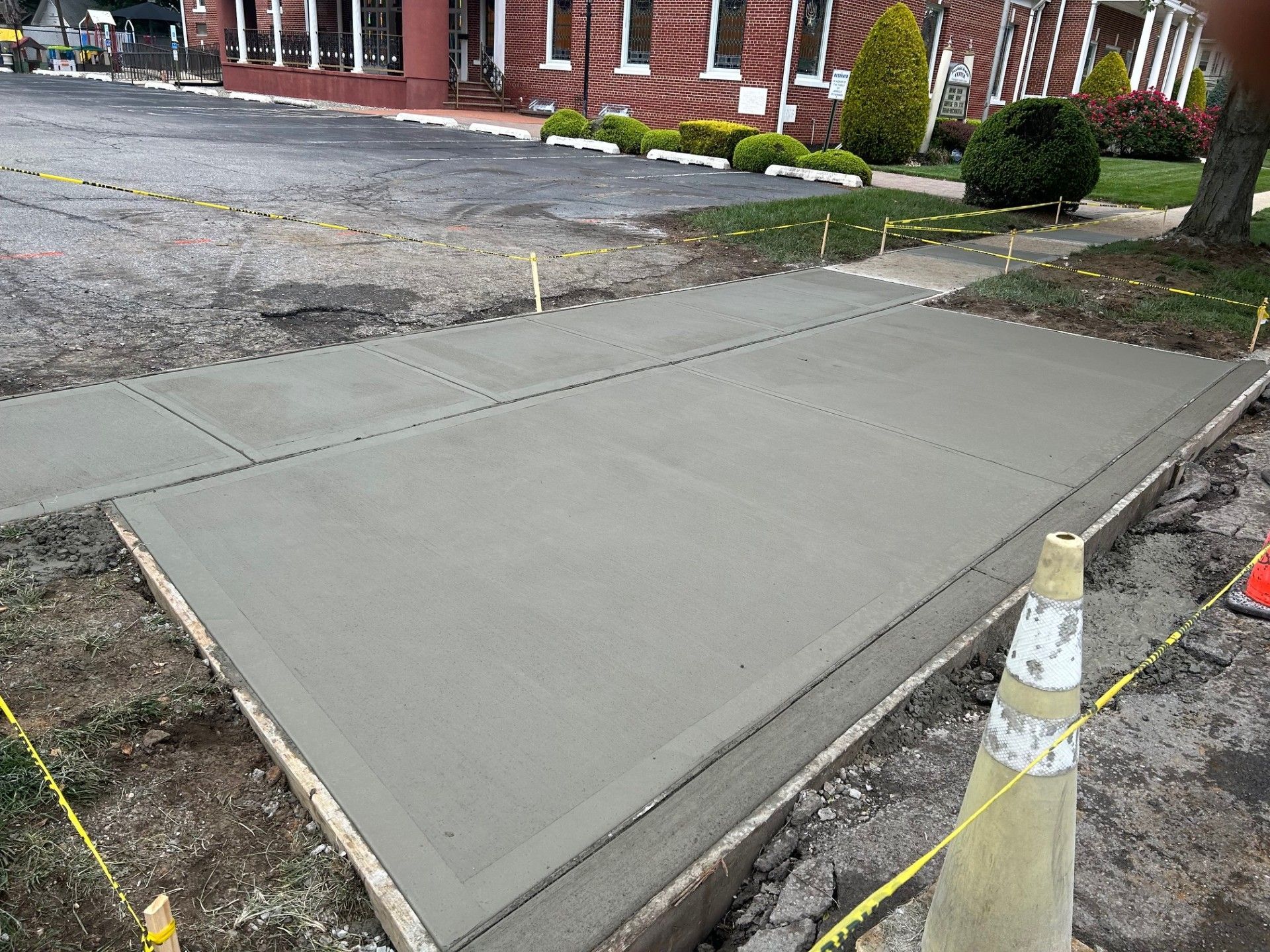 A concrete sidewalk is being built in front of a building.