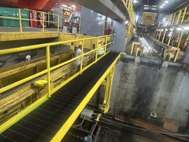 Workers are applying yellow paint to the indoor railings.