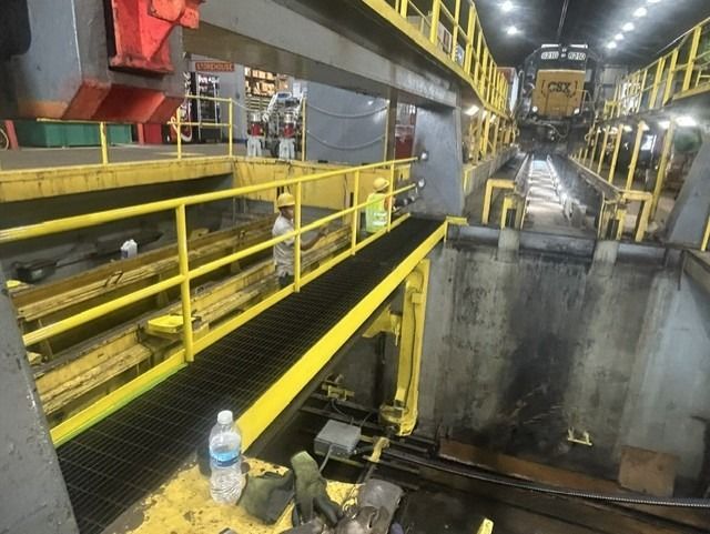 The indoor railings are being painted yellow by workers.