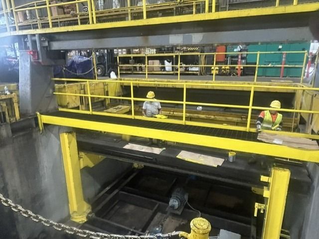 Workers are giving the indoor railings a fresh coat of yellow paint.