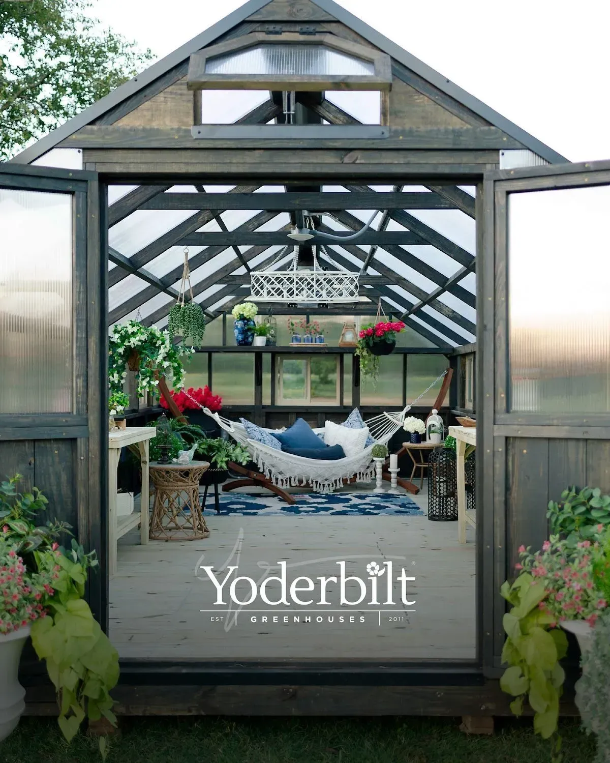 Greenhouse interior with hammock, plants, and blue accents. Yoderbilt logo at bottom.