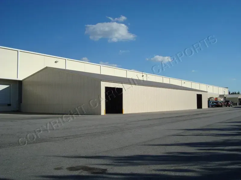 Long beige industrial building with loading docks on a sunny day.