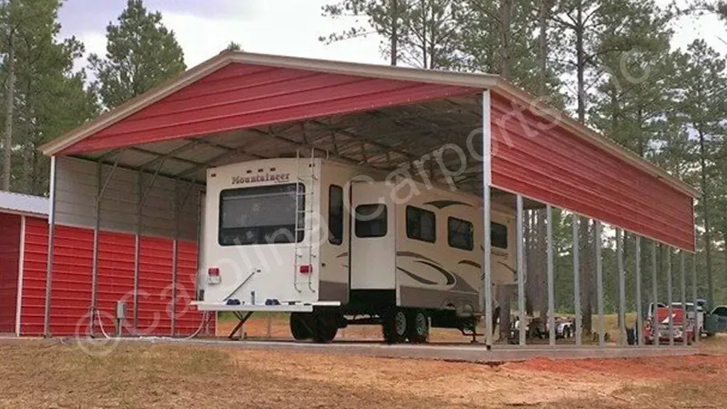 RV parked under a red metal carport on a grassy lot.