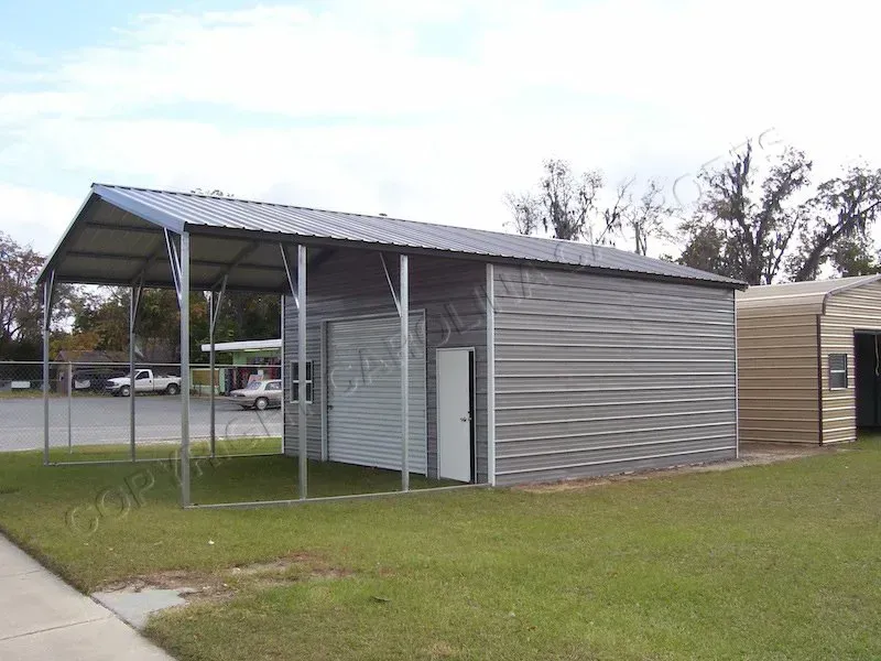 Metal carport and enclosed storage building on a green lawn, next to a sidewalk and fence.