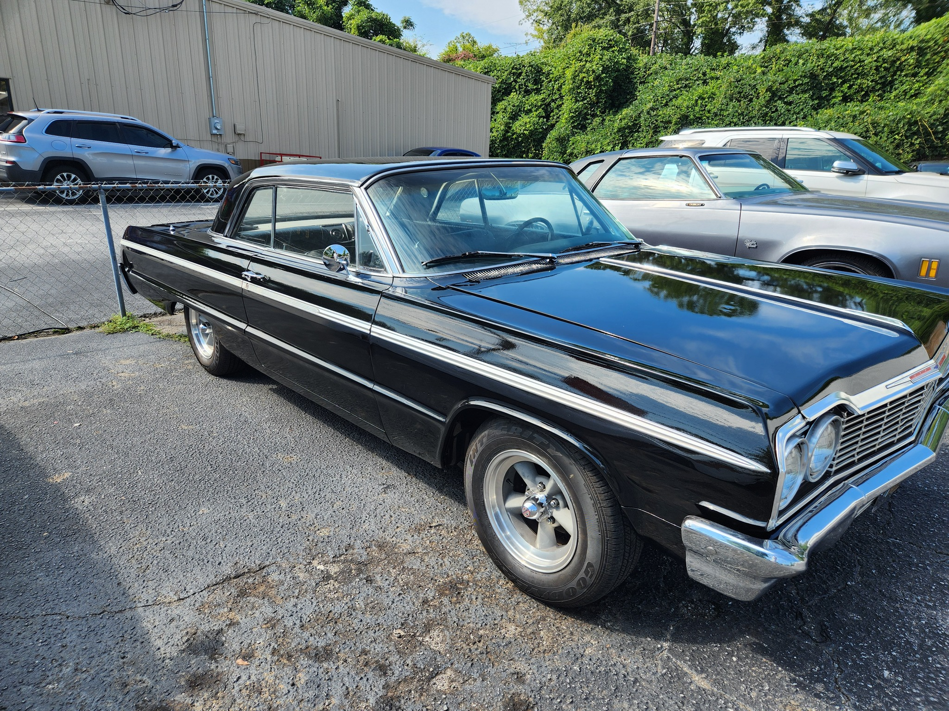 Black vintage Chevrolet Impala parked outdoors.