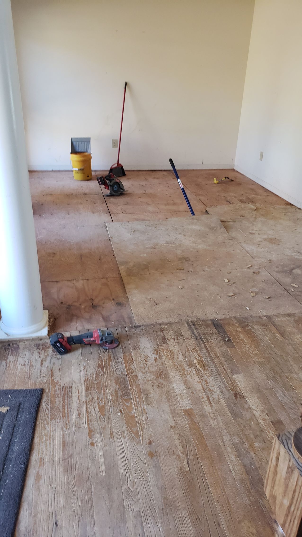 A scissors is sitting on the floor of a basement.