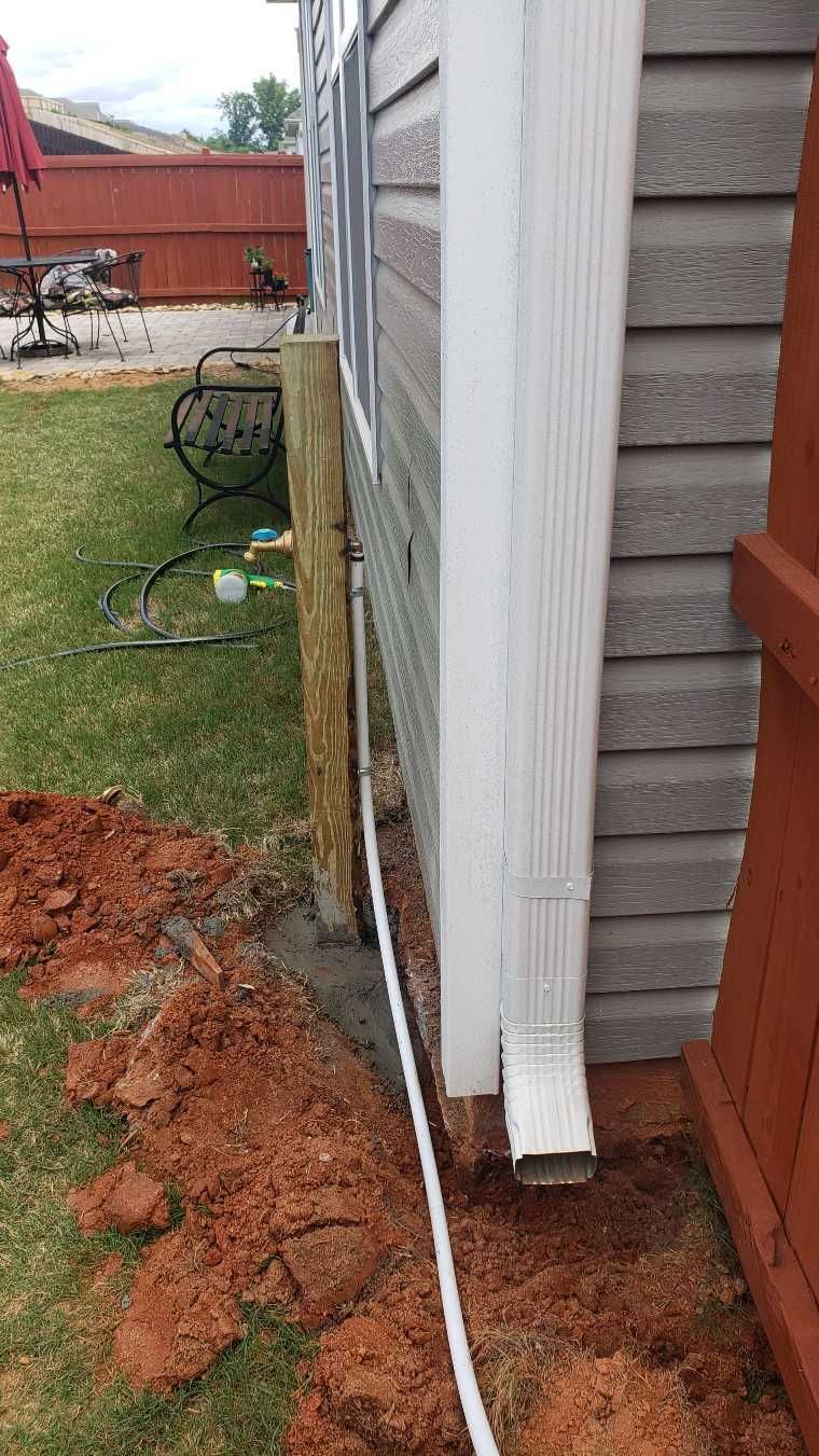 A house with a drain pipe on the side of it.