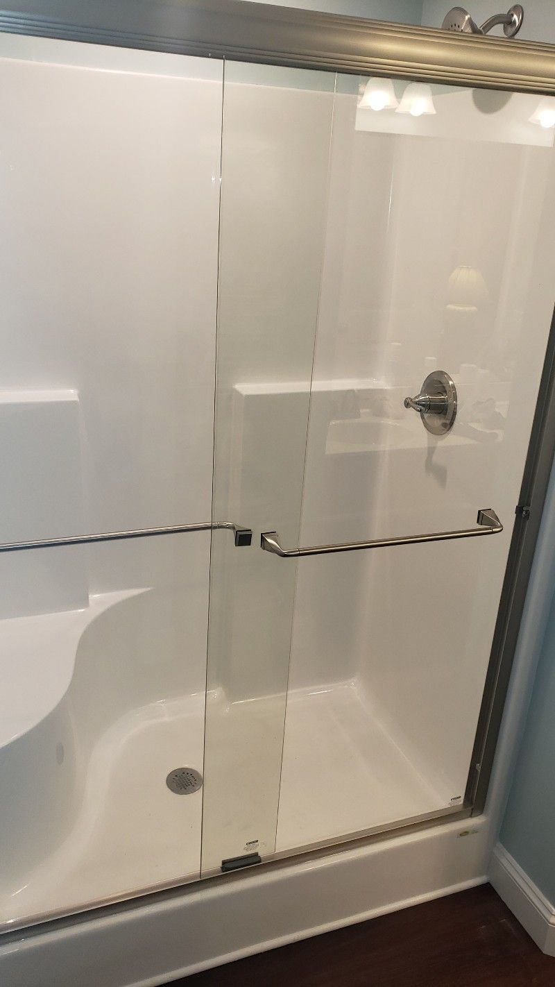 A bathroom with a sliding glass shower door and a toilet.