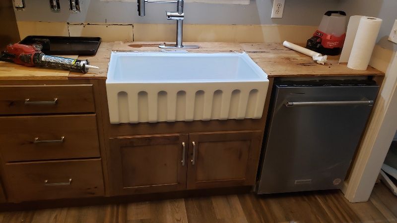 A kitchen with a sink , cabinets , and a dishwasher.