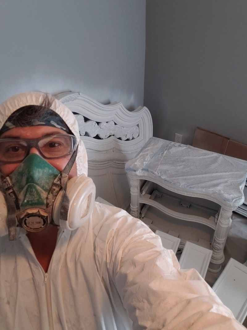 A man wearing a gas mask and goggles is taking a selfie in a room.