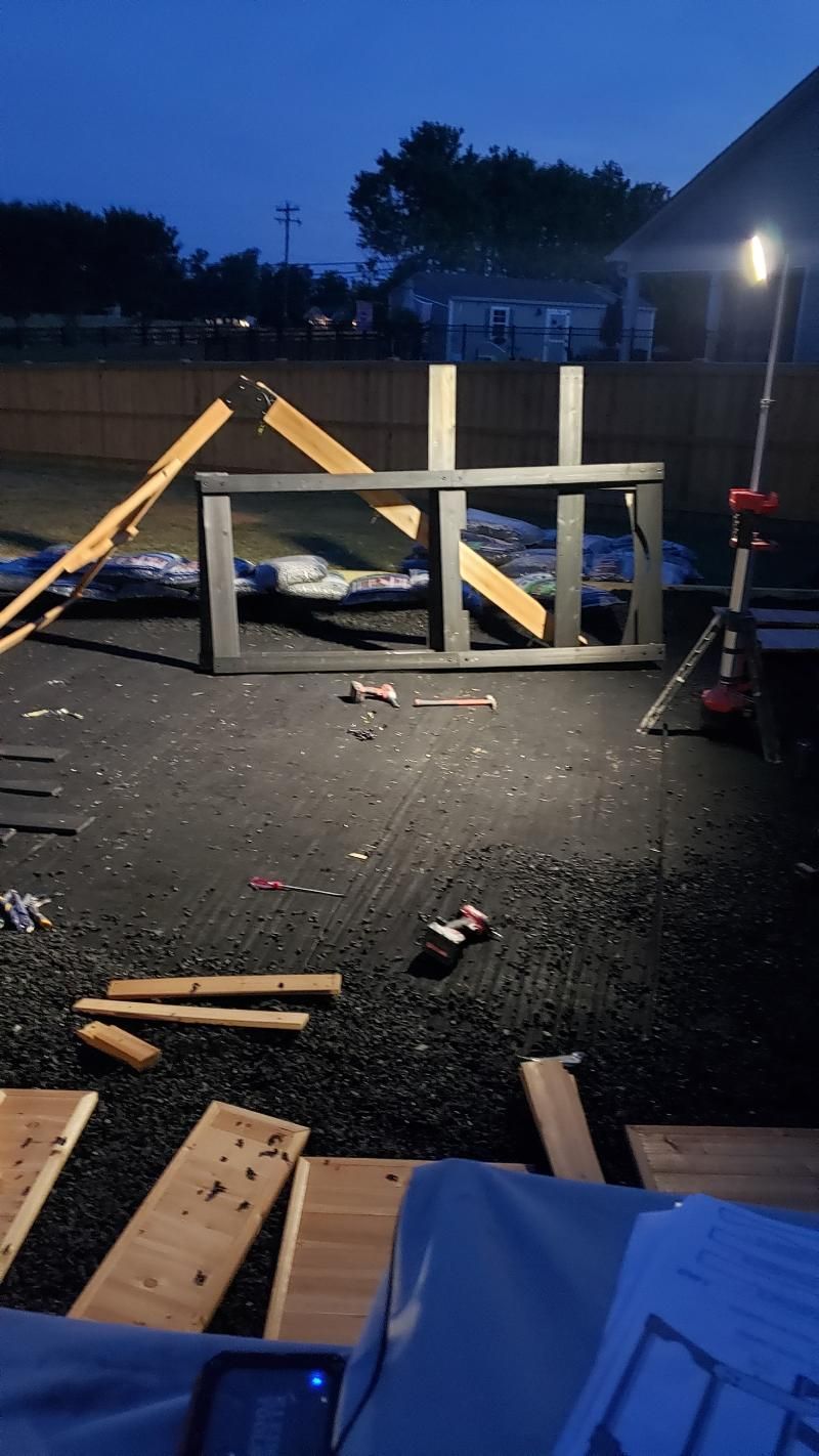 A bunch of wood is laying on the ground in a dark room.