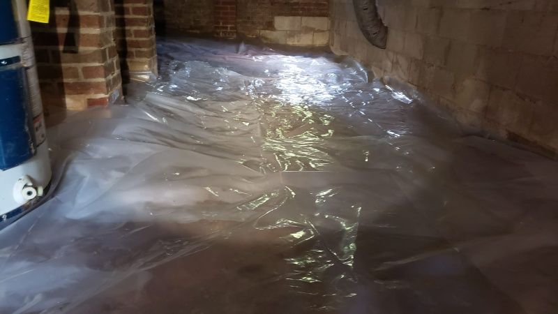 A basement filled with water and plastic covering the floor.