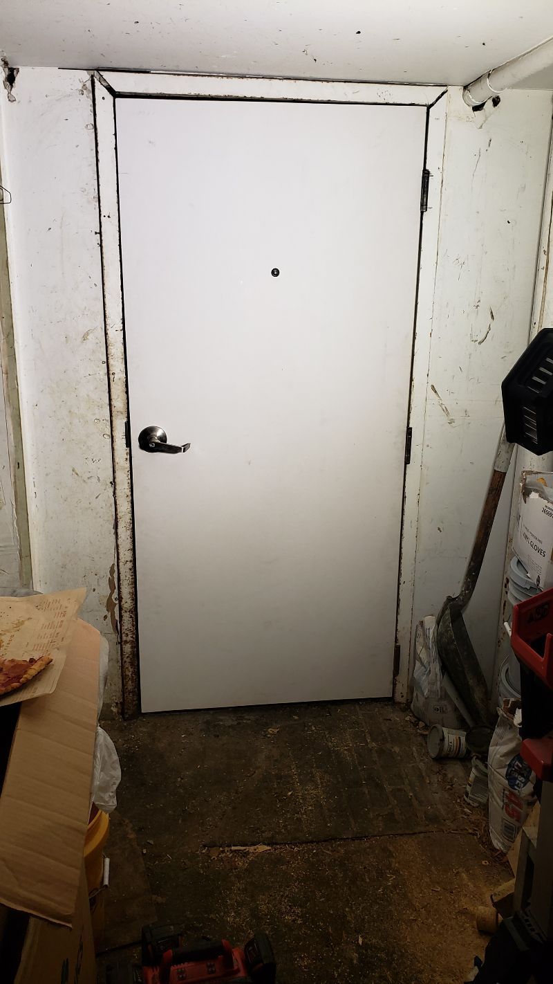 A white door with a black handle is in a room.