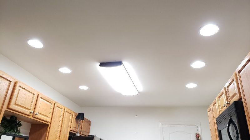 A kitchen with wooden cabinets and a ceiling light