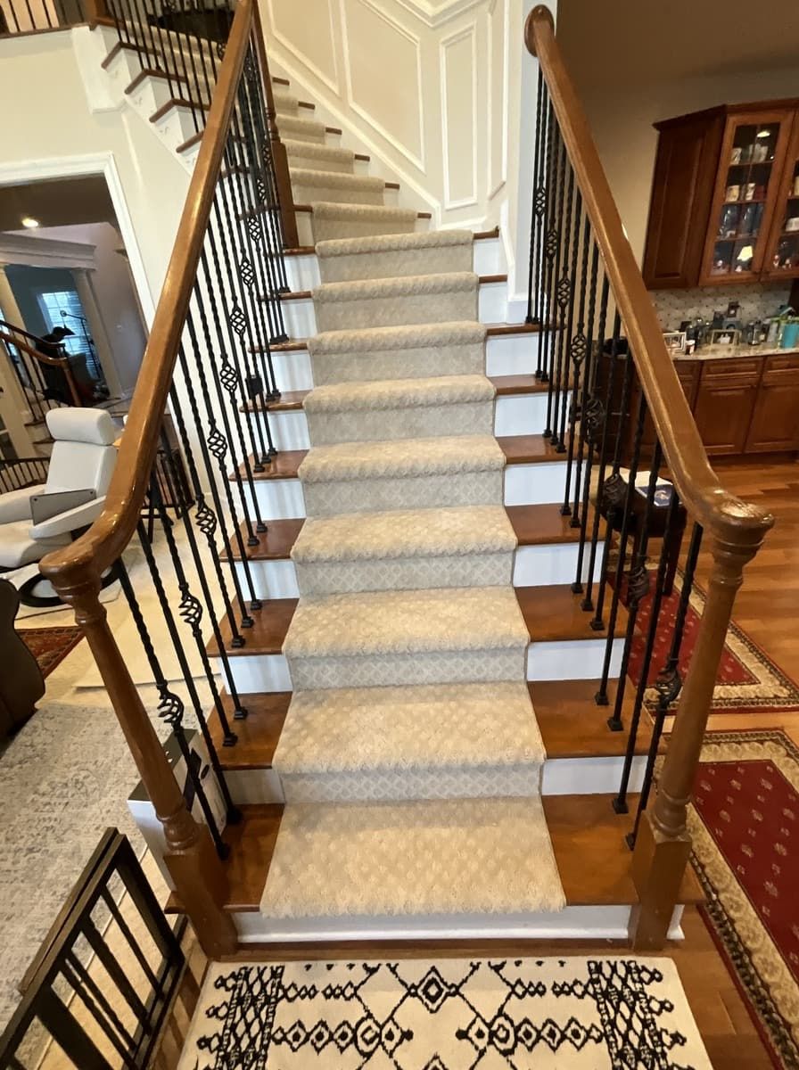 A staircase with a carpet on the steps and a wooden railing.