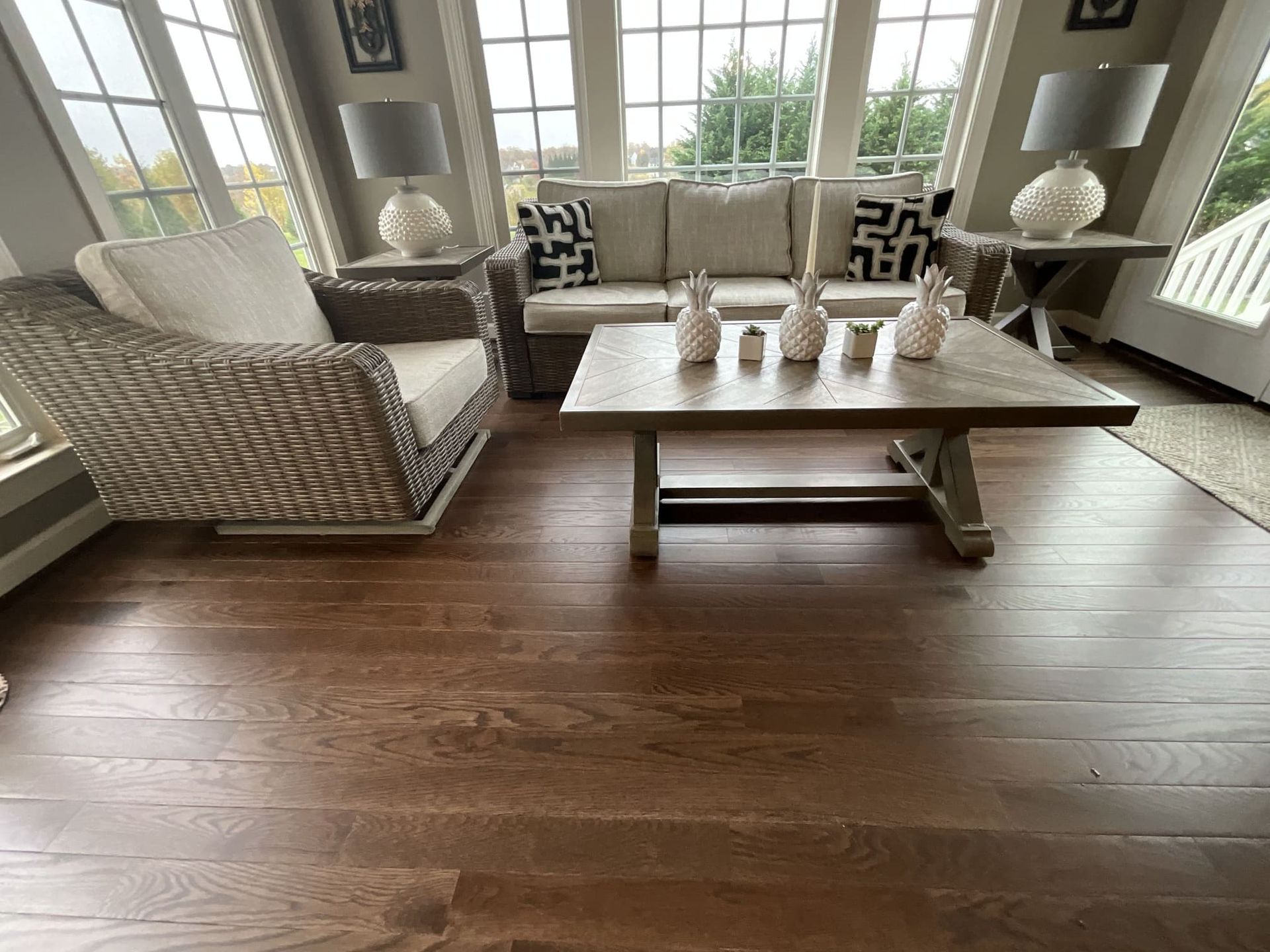 A living room with a couch , chair , coffee table and lamps.