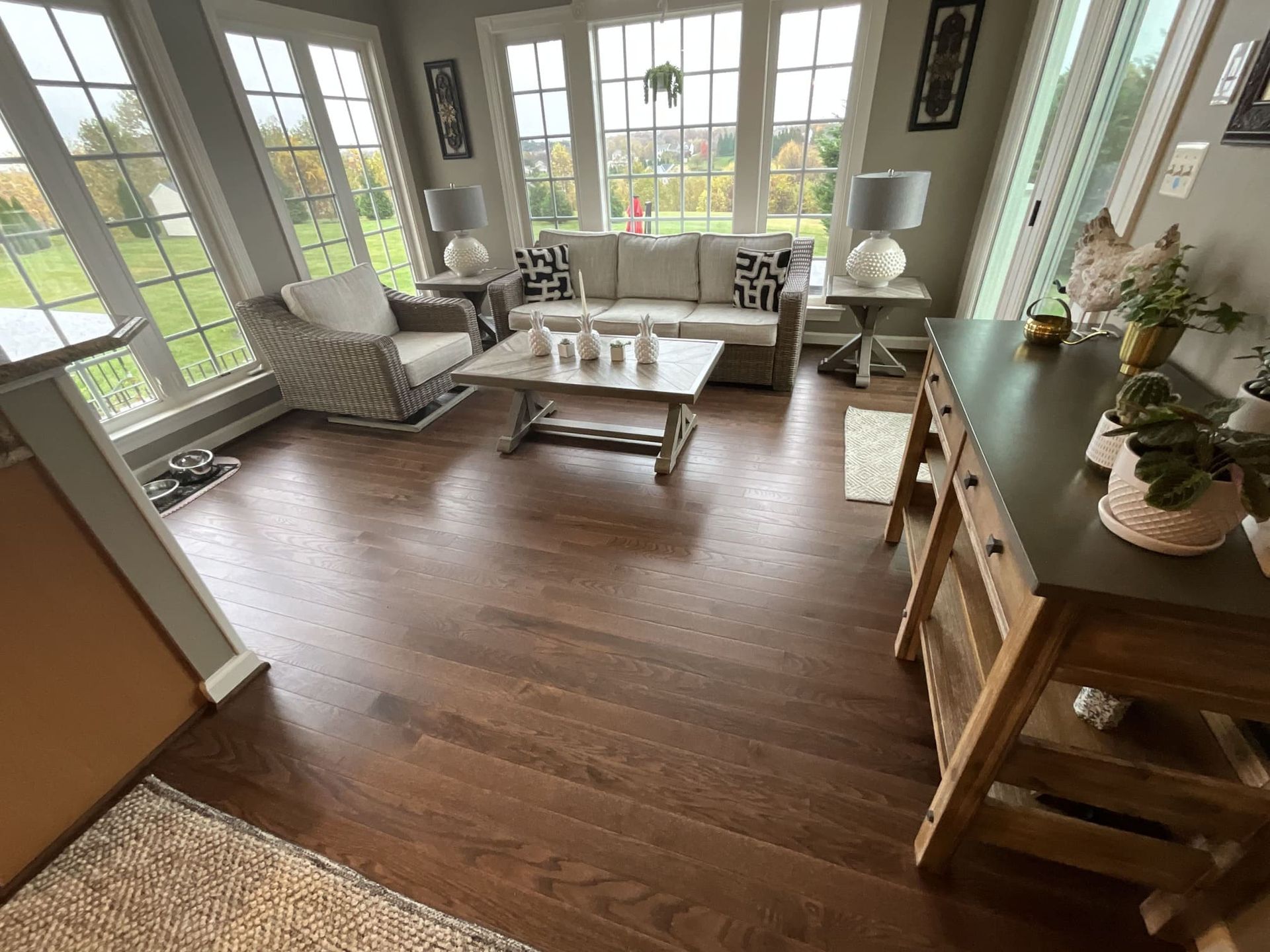 A living room with a couch , chair , coffee table and lots of windows.