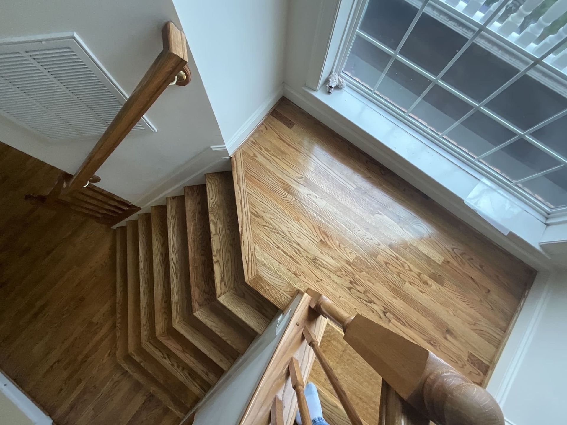 An aerial view of a wooden staircase with a window in the background.