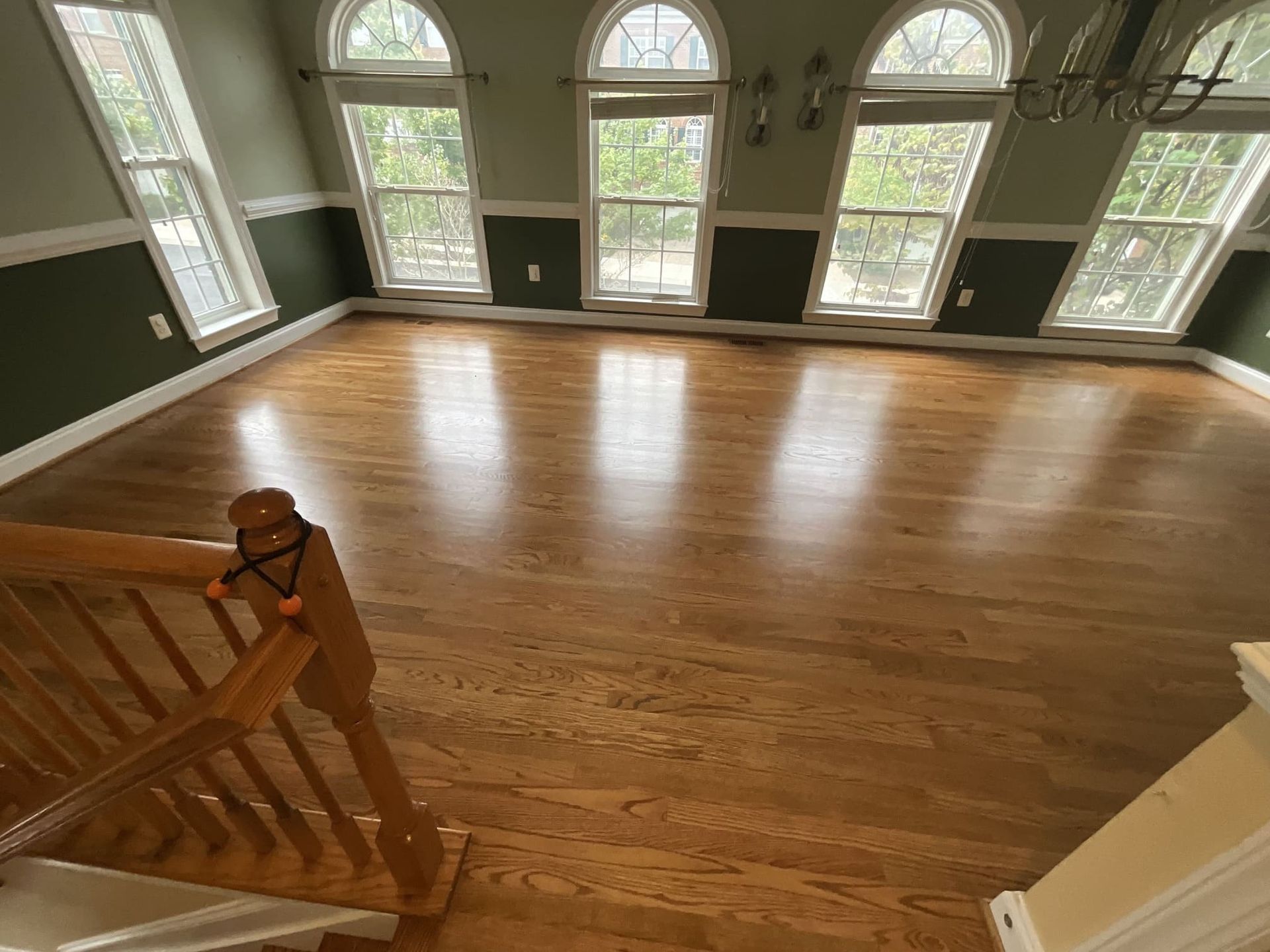 A large empty room with hardwood floors and lots of windows.