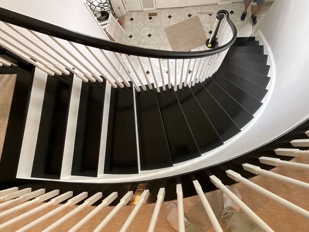 A black and white spiral staircase with a white railing