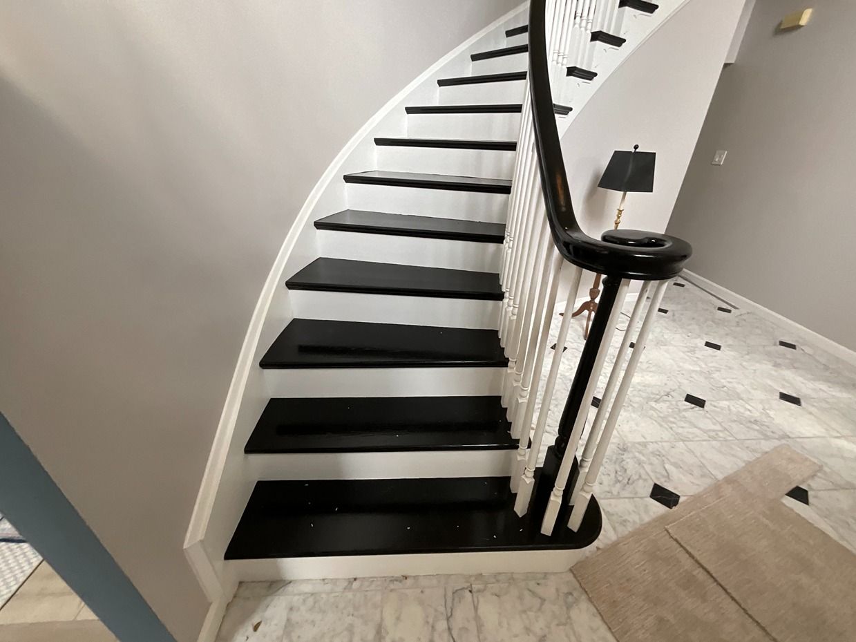 A black and white staircase with a white railing