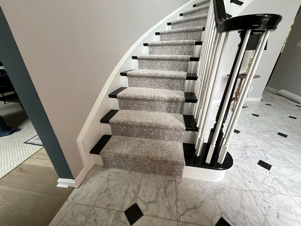 A staircase with a carpeted staircase and a black railing.