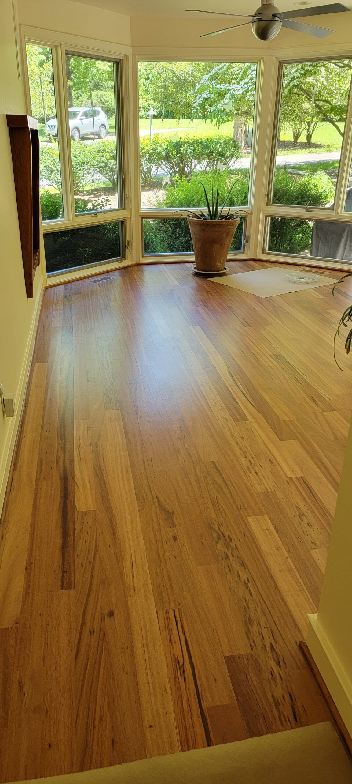 A living room with hardwood floors and a ceiling fan.
