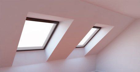 There are two skylights in the ceiling of a room.