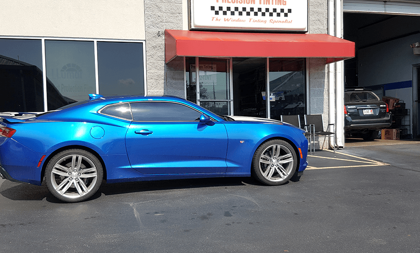 Side view of a 2-door blue car with tinted windows