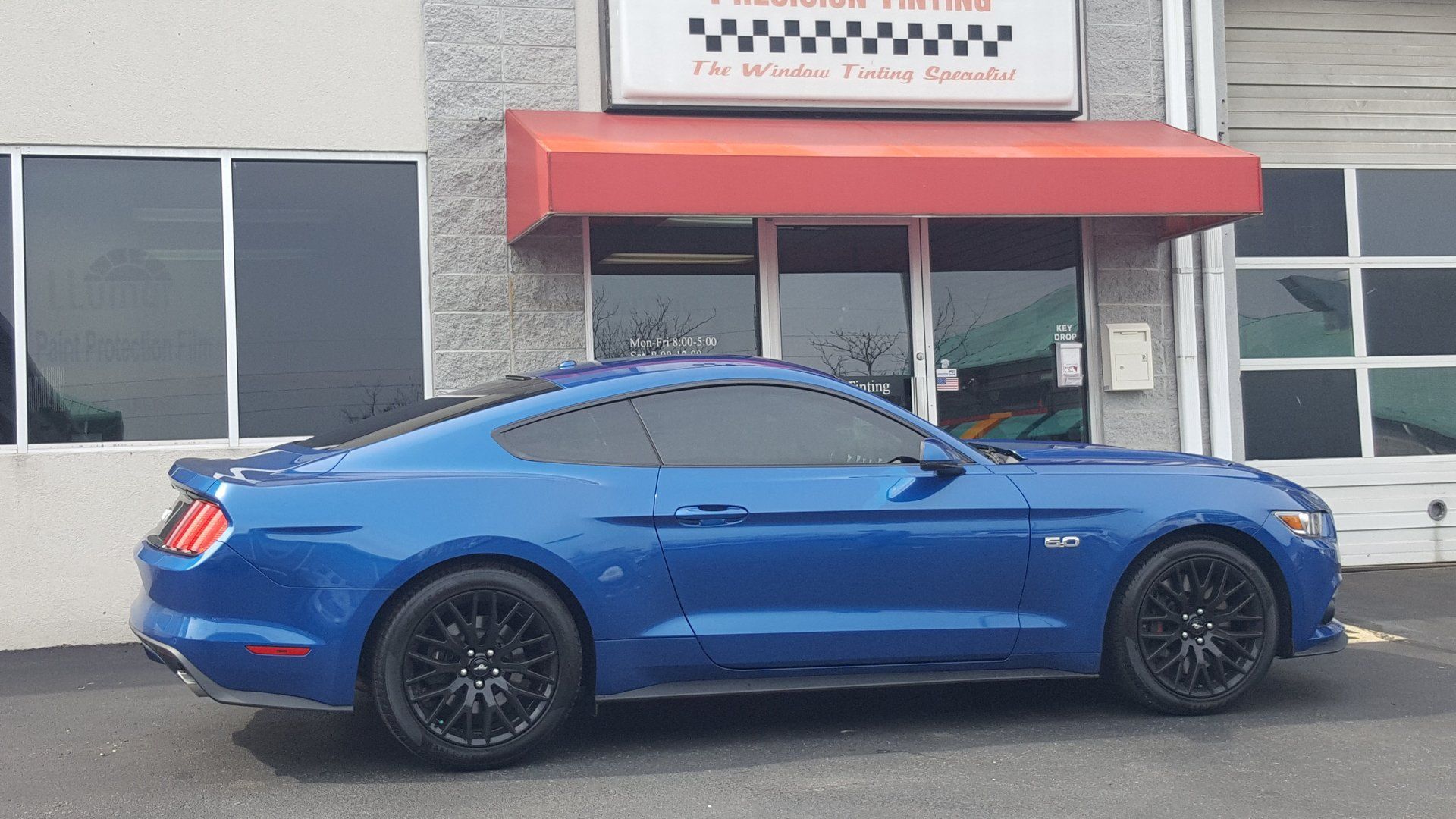 Blue car in front of Precision Tinting Inc's building