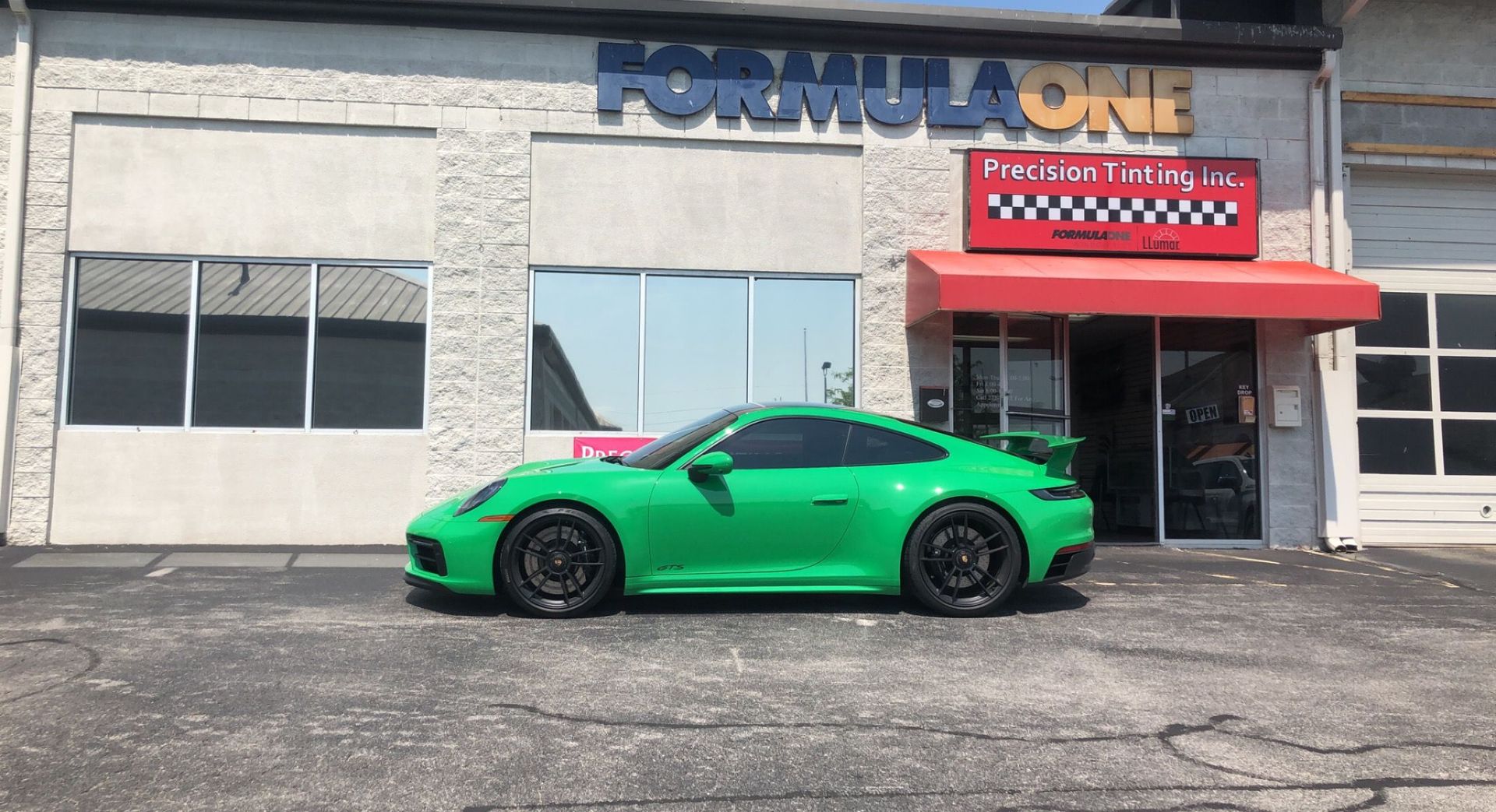 Side view of a green sports car with tinted windows 